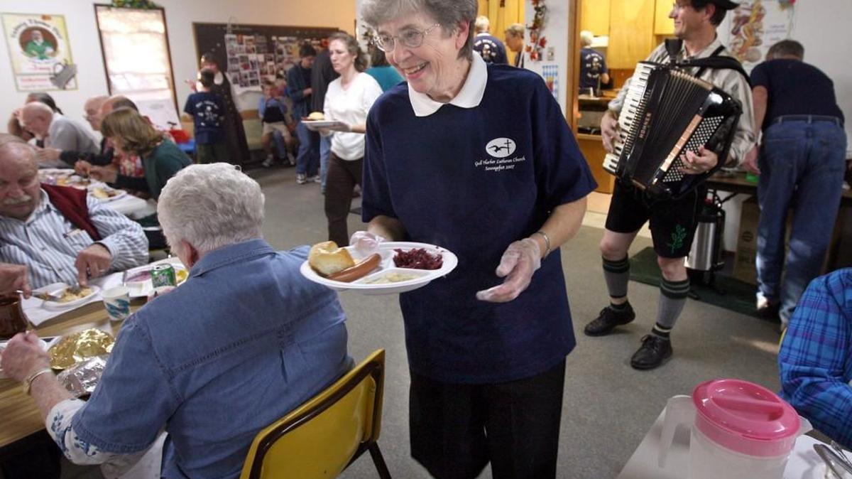 
Carol McCormick, a volunteer with the Lutheran Church of the Good Shepherd on North Street, serves meals during the 2007 Sausage Fest at the Gull Harbor Lutheran Church on Boston Harbor Road. In the background at right, Lyle Schaefer plays polka tunes on the accordion. The last Sausage Fest is today at the church.

