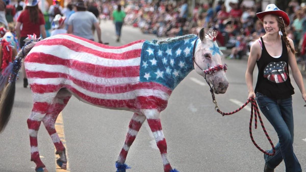 Evita Skerse, 15, walks Shieba the patriotic horse as they march with the Healing Hearts Ranch during the annual Tumwater’s 2013 Fourth of July parade.