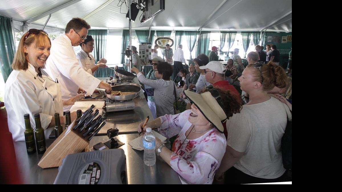 
The audience rush to the stage to enjoys samples after Chefs Laurel Khan(left) ,Ed Lintott and Crystal Robinson prepared several mushroom recipes using a variety of oils from the Olympia Olive Oil and Vinegars company during their Sunday cooking demonstration at the 2014 Mushroom Festival in the Regional Athletic Complex.The trio represented the Human Touch Chefs Group, a non-profit organization focused on educating the public on food sustainability,healthy eating options and the return to the traditional, at-home family dining experience.
