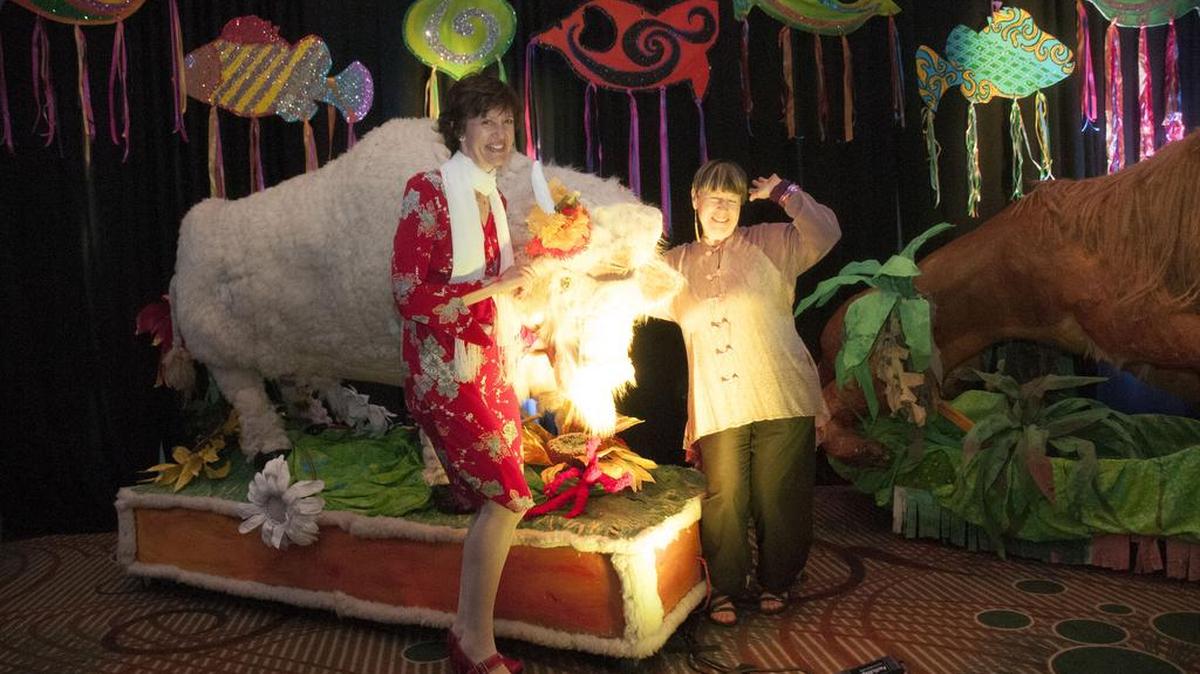Susan Gresia, left, and Mary Nelson get friendly with the procession’s buffalo.