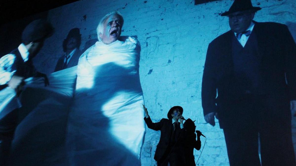 
Artist, filmmaker and musician Rachel Mason performs in front of a projection of her rock-opera film “The Lives of Hamilton Fish” (with actors playing the serial killer Hamilton Albert Fish, left, and the politician Hamilton Fish II, right), at the Los Angeles County Museum of Art in June.
