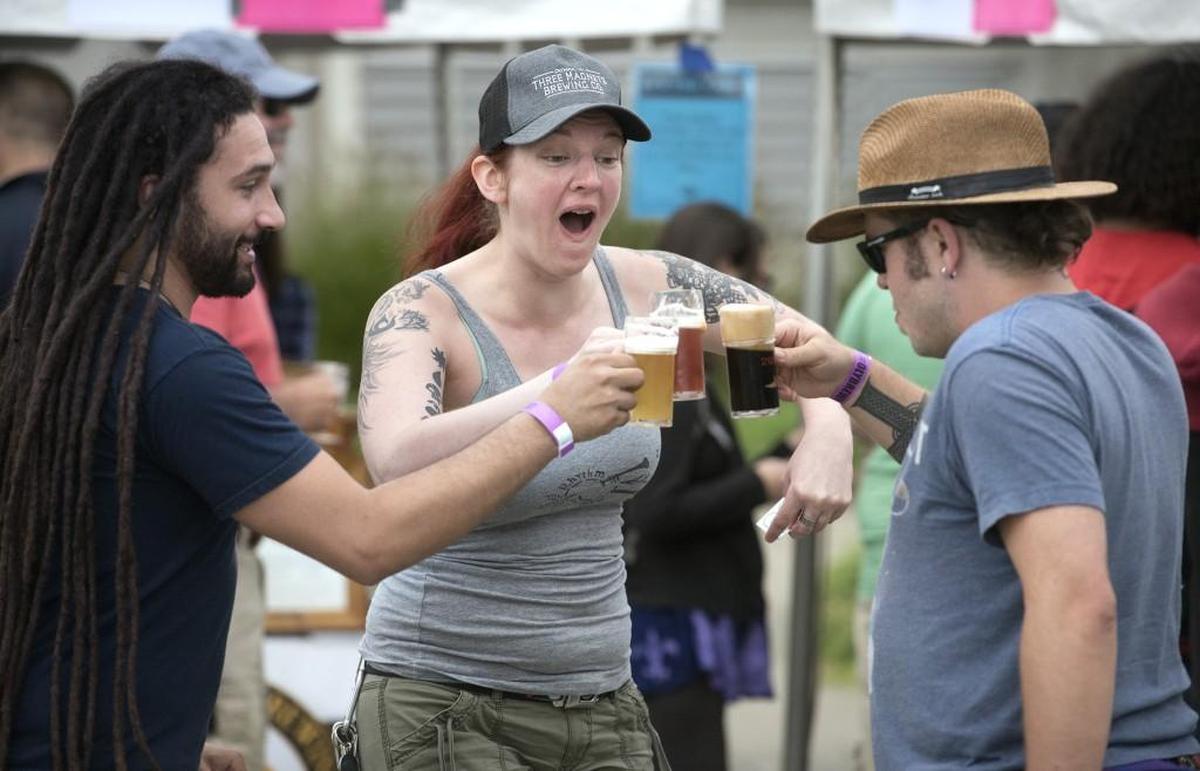 Erin Gill reacts as a toast with friends Shiva Diamond (left) and Ben Wright turns foamy during the Olympia Brew Fest at the Port Plaza in 2016.