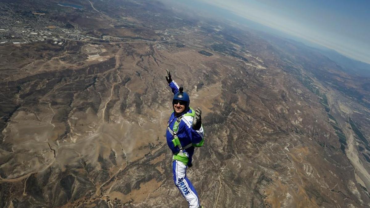 In this Monday, July 25, 2016 photo, skydiver Luke Aikins smiles as he jumps from a helicopter during his training in Simi Valley, Calif. After a two-minute freefall Saturday, Aikins landed dead center in the 100-by-100-foot net at the Big Sky movie ranch.