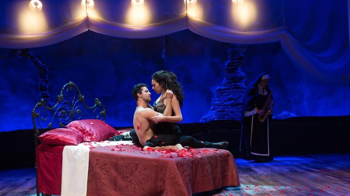 Sebastian Jose Castillo (Eduardo Enrikez, left) and Pilar Esperanza Castillo (Esperanza America) share a romantic encounter in the Oregon Shakespeare Festival’s “Destiny of Desire” by Karen Zacarías. Sister Sonia (Catherine Castellanos) provides musical accompaniment.