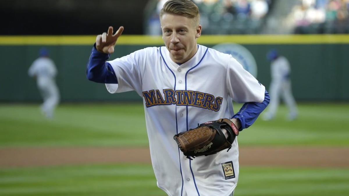 Singer and hip-hop artist Macklemore, shown after throwing out the first pitch at a Seattle Mariners baseball game April 29, will tour eight Washington towns with Ryan Lewis.