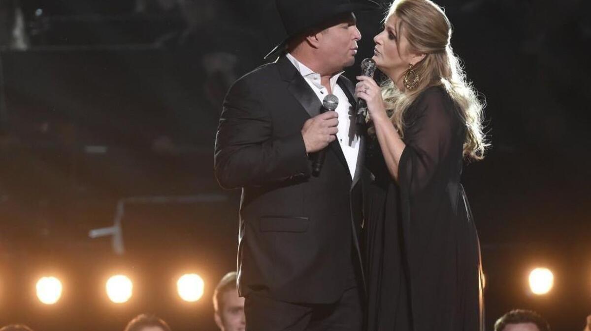 FILE - In this Nov. 2, 2016, file photo, Garth Brooks, left, and Trisha Yearwood perform at the 50th annual CMA Awards at the Bridgestone Arena in Nashville, Tenn. The Lafayette Daily Advertiser reported July 27, 2017, that Brooks and Yearwood bought wedding gifts for a couple who came to a concert in Louisiana last month ahead of their wedding last month. (Photo by Charles Sykes/Invision/AP, File)