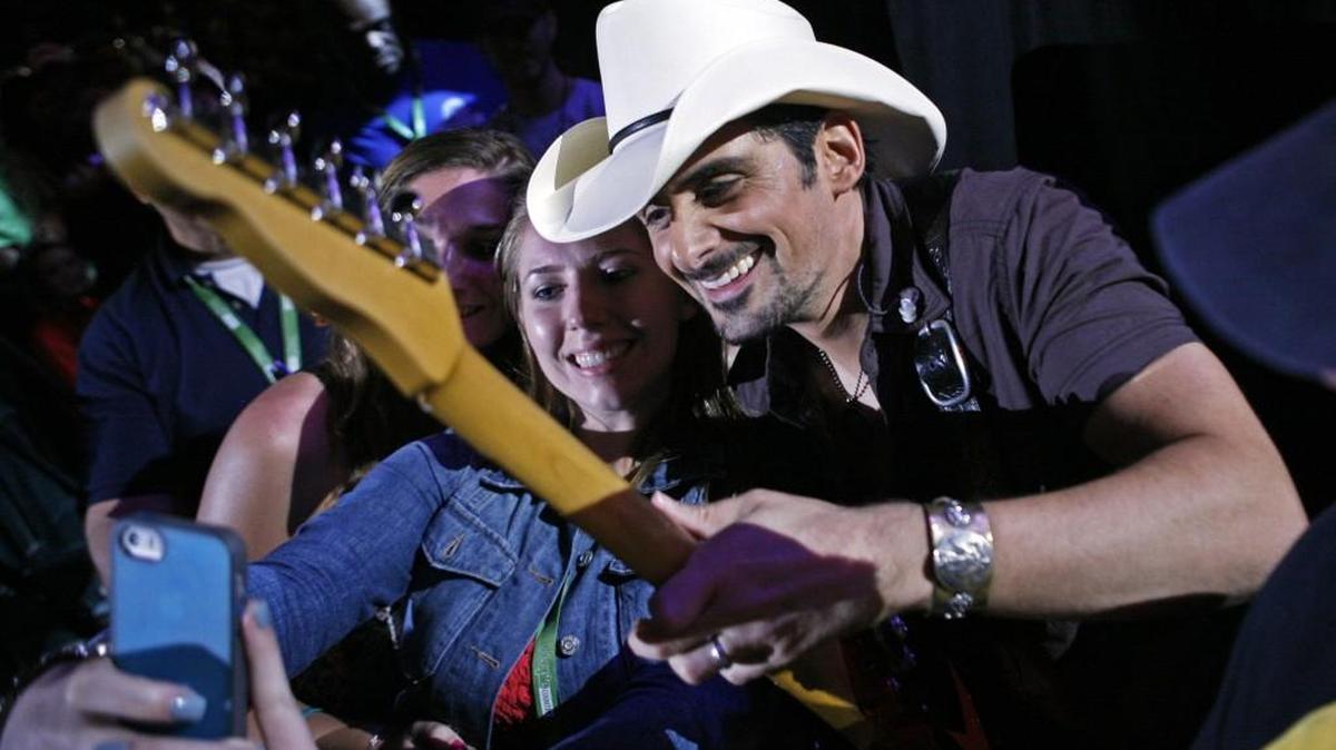 Brad Paisley poses while a fan takes a photo during the CMA Fest at LP Field in Nashville, Tenn., in 2014.