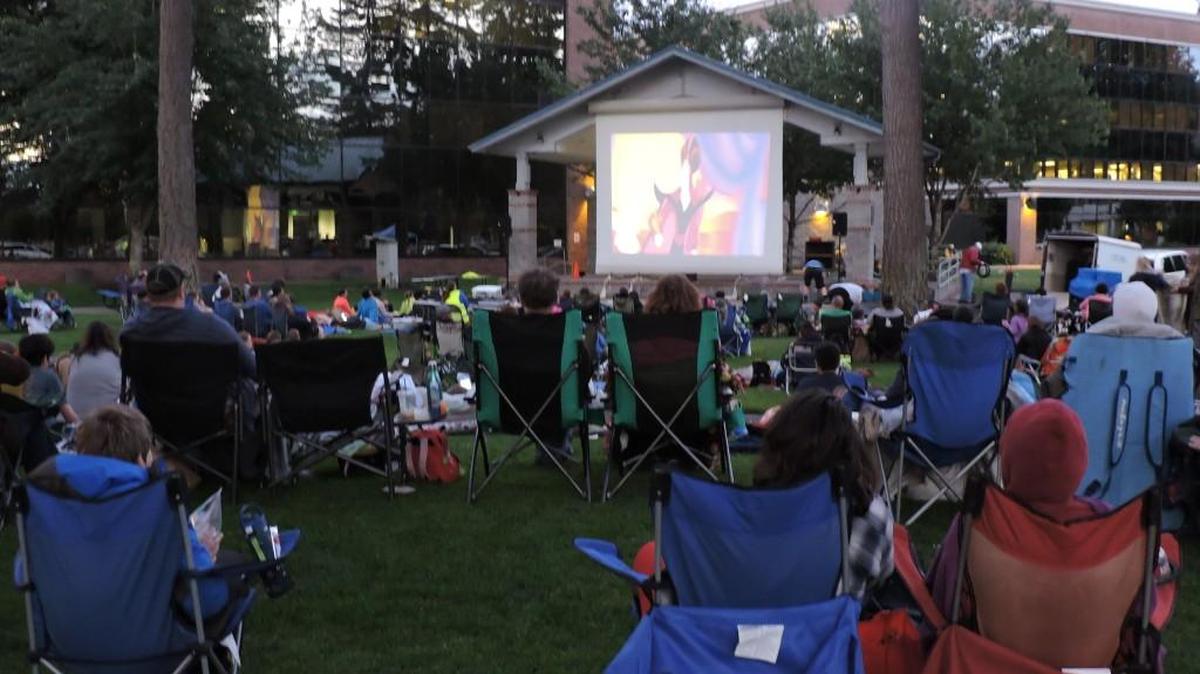 Movie watchers take in a flick during an Saturday night outdoor screening that is part of Lacey in Tune. The screen at Huntamer Park is 18 feet by 18 feet.