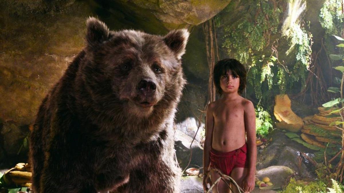 In this image released by Disney, Mowgli, portrayed by Neel Sethi, right, and Baloo the bear, voiced by Bill Murray, appear in a scene from, “The Jungle Book.”