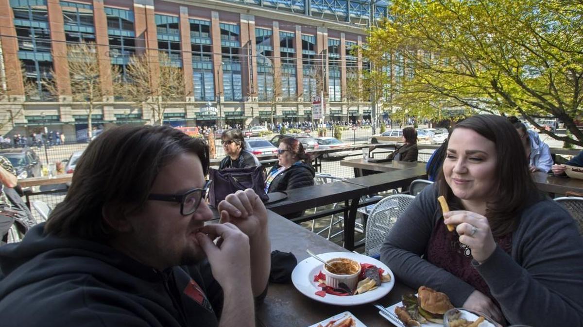 Chris Dickey, left, and Misti Turner enjoy a meal at Pyramid Alehouse with Safeco Field in the background in Seattle on Friday, Mar. 25, 2016. The two said the chorizo dip is amazing.