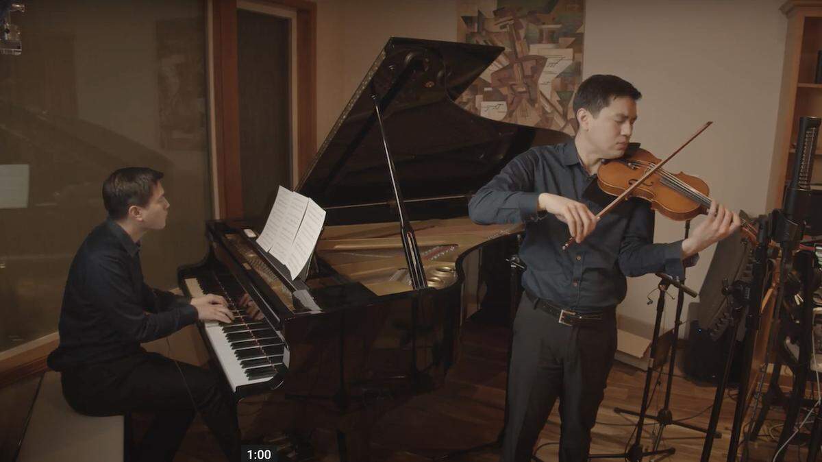 Look closely: The same man, Jason Leng, is playing both piano and violin, performing the love theme from Cinema Paradiso. He also combined the performances on both instruments into a singular video.