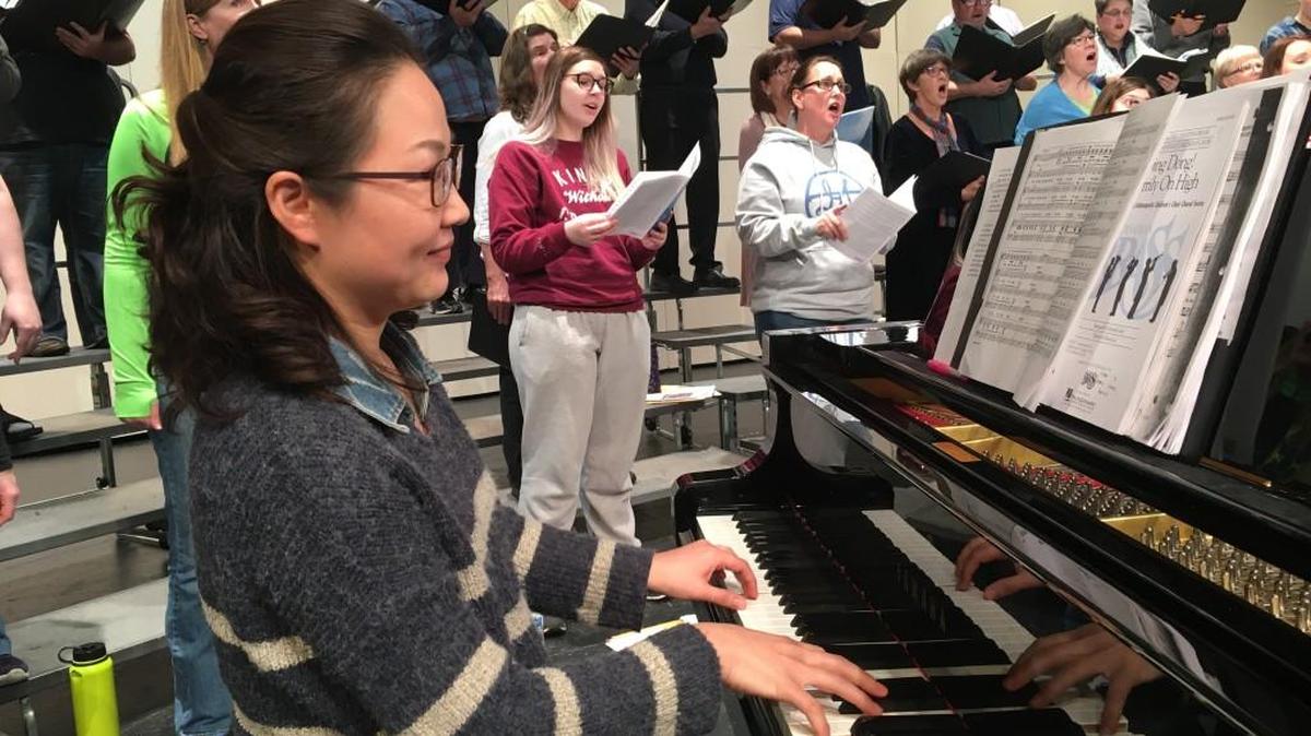 Accompanist Hannah Cho and members of the chorus rehearse.
