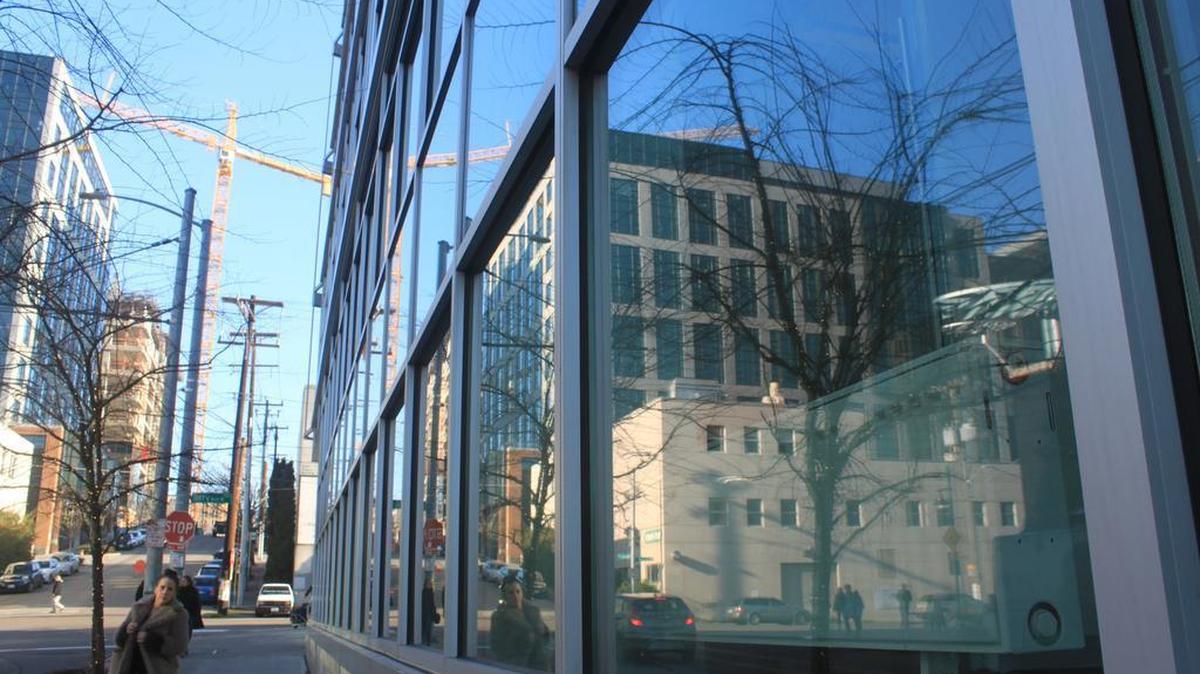 A building under construction is reflected in a window on Thomas Street in Seattle’s South Lake Union neighborhood.