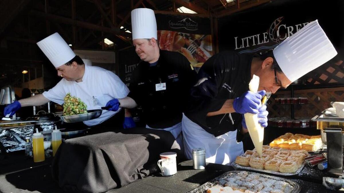 Little Creek Casino executive chef Troy Sandoval finishes a row of desserts while chefs Brian Marx (center) and Christophe Durliat prepare vegetable and seafood dishes at the 2014 Taste of the Market at the Olympia Farmers Market. This year’s Taste of the Market fundraiser is Tuesday.