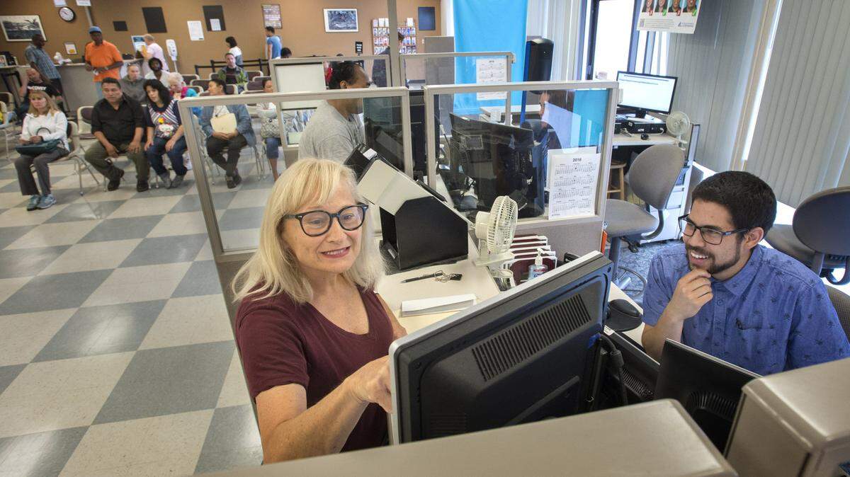 Michelle Henrich answers security questions for an enhanced drivers license with help from licensing service representative Tevin Joseph in 2016. The Department of Licensing is shutting down for almost a week to upgrade its database system, and state residents won’t be able to get licenses or register to vote during that time.