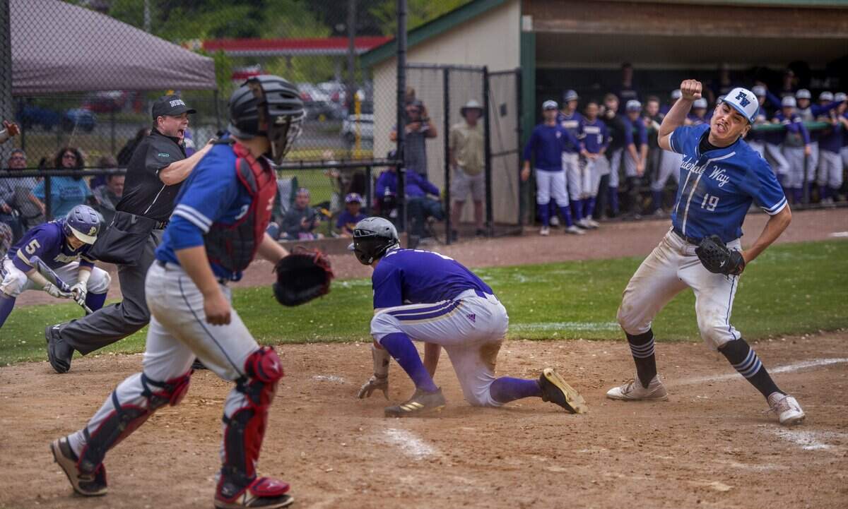 Pitcher Brandham Ponce of Federal Way High School pumps his fist after he tagged Evan Scavotto of Puyallup who tried to steal home in a 4A boys baseball playoff game held at Heidelberg Field in Tacoma, May 19, 2018.  Federal Way beat Puyallup, 6-5 in 8 innings.
