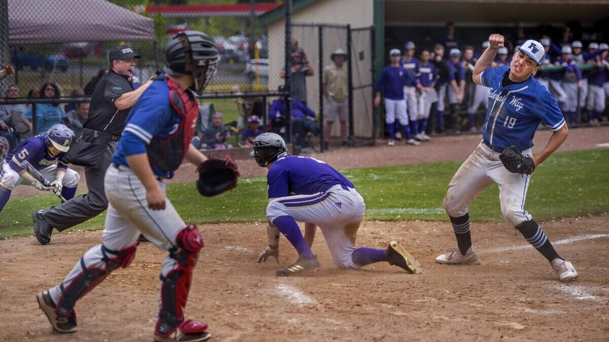 Pitcher Brandham Ponce of Federal Way High School pumps his fist after he tagged Evan Scavotto of Puyallup who tried to steal home in a 4A boys baseball playoff game held at Heidelberg Field in Tacoma, May 19, 2018.  Federal Way beat Puyallup, 6-5 in 8 innings.