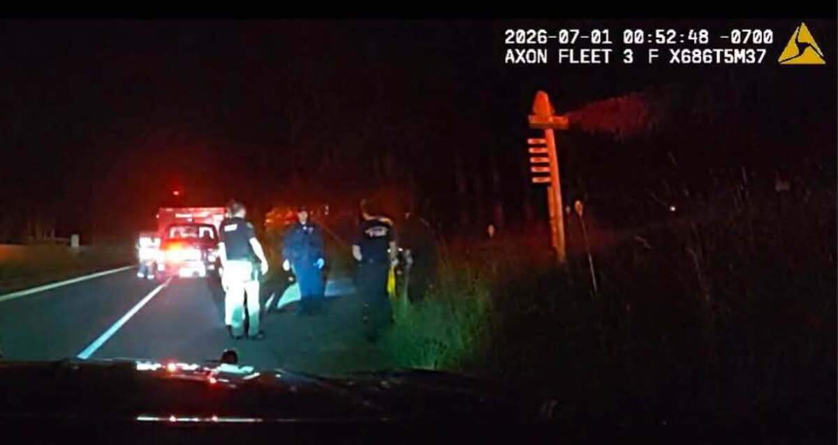 First responders stand on the 6800 block of Fir Tree Road Southeast early Wednesday morning after helping a woman who gave birth in a vehicle. Sheriff Derek Sanders shared a still image of dash camera footage from a patrol vehicle at the scene to his Facebook page.