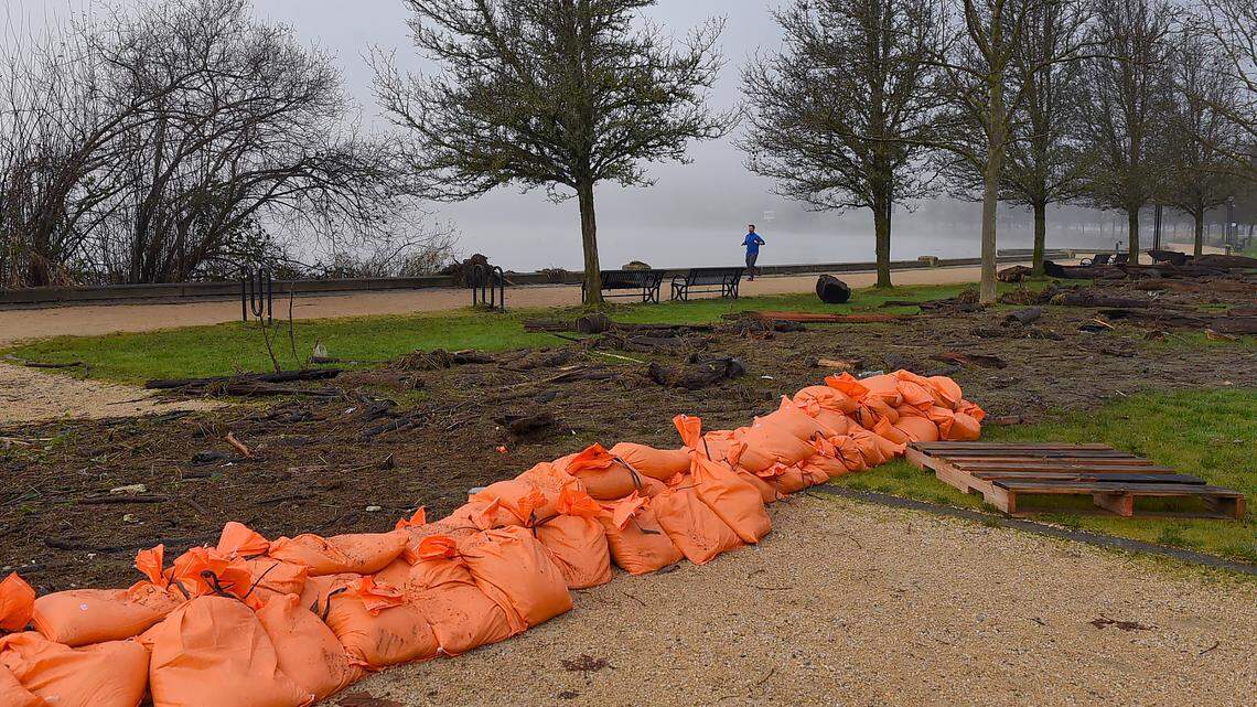 Debris and stacked sandbags remain after flooding along Capitol Lake in Olympia on Sunday.