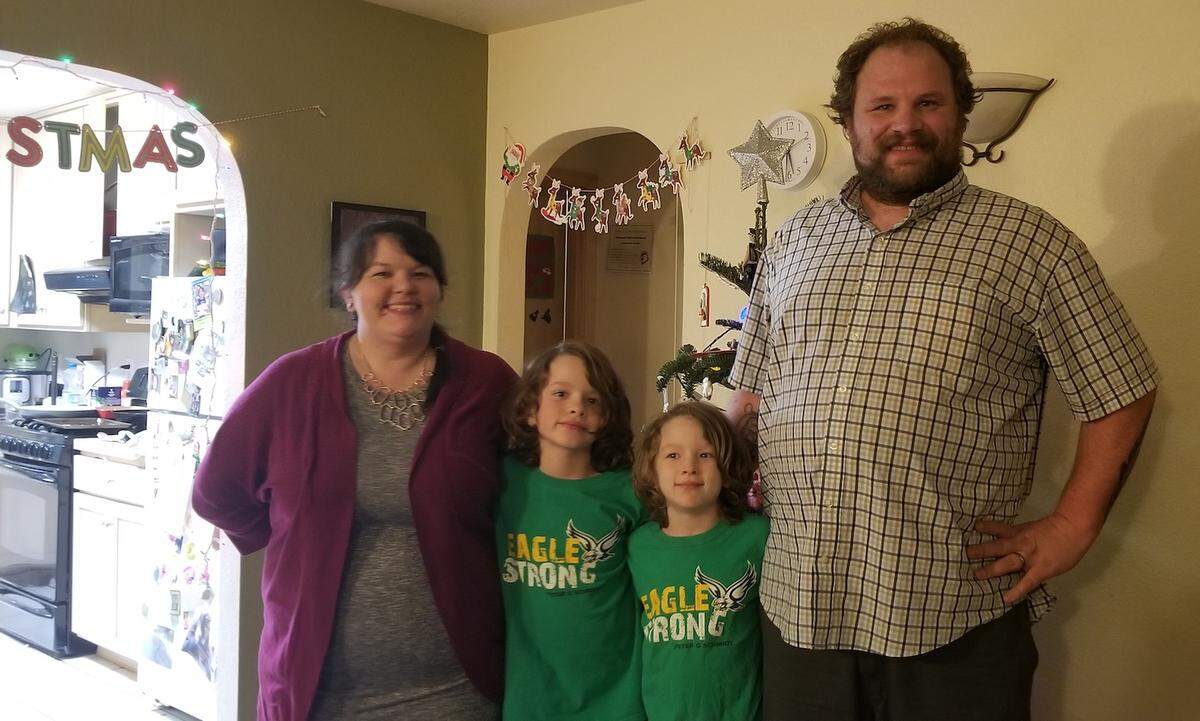 Taller than his tree, Sam Miller is spending the season with his wife, Brittney Miller, and sons Oliver (left), 6 and in first grade at Peter G. Schmidt Elementary in Tumwater, and Buddy, 9 and in third grade at Schmidt.