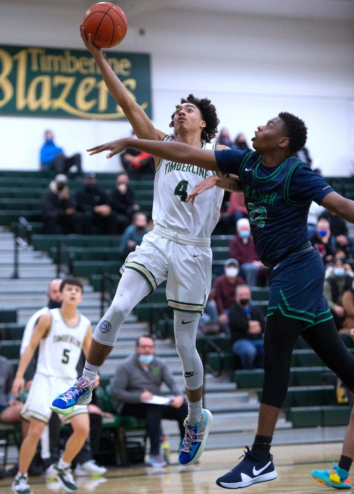 Timberline’s Brooklyn Hicks flies to the basket in front of Todd Beamer defender Ismail Ismail during Saturday night’s West Central III/Southwest bidistrict tournament boys basketball opening-round game at Timberline High School in Lacey, Washington, on Feb. 12, 2022. Timberline won the game, 70-40.
