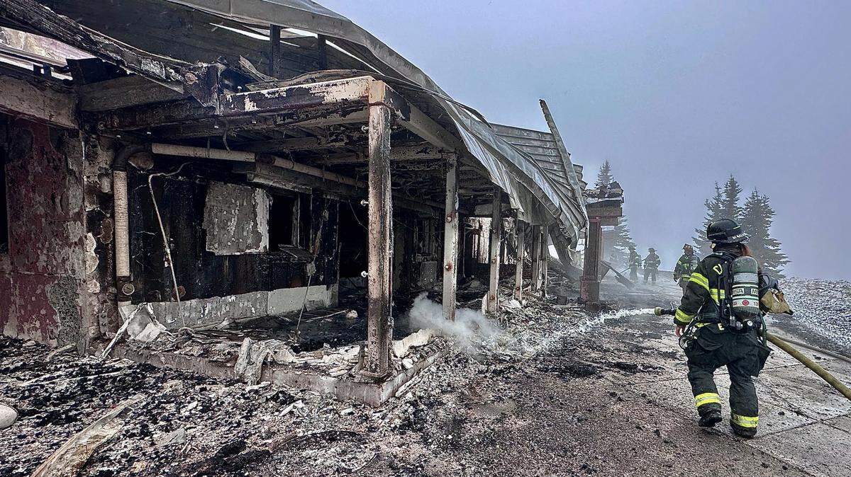 Clallam County Fire District 2 firefighters inspect the smoldering remains of the Hurricane Ridge day lodge. The Olympic National Park lodge was destroyed by fire Sunday while it was closed to renovations. The lodge was due to reopen Memorial Day weekend.