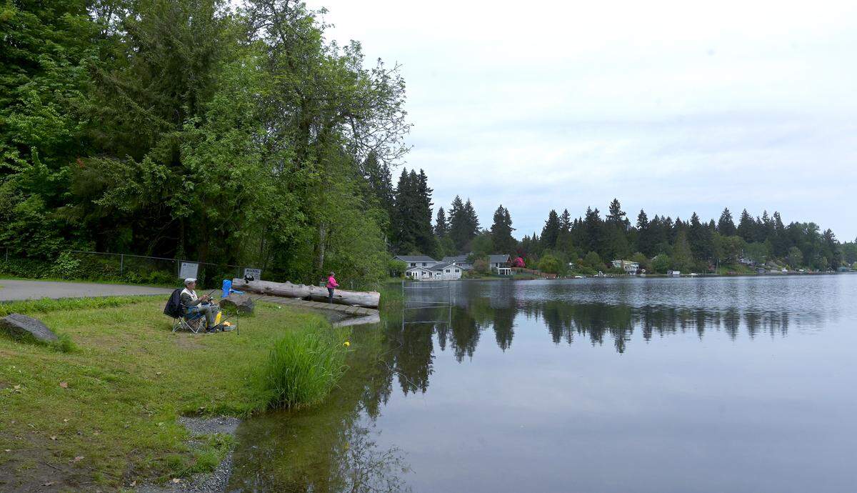 Folks enjoy a pleasant Thursday afternoon fishing at the Hicks Lake Boat Launch near Wanschers Park in Lacey, WA. On May 26, 2022. Both locations are close to a controversial housing project that many nearby residents are opposing