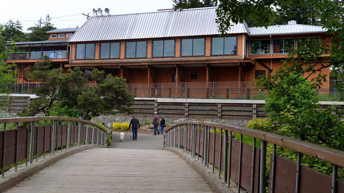 The landmark Falls Terrace restaurant serves as a backdrop as visitors to Brewery Park at Tumwater Falls enjoy a pleasant lunchtime walk on June 1.