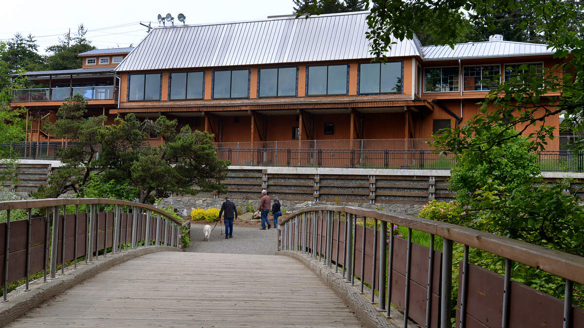 The landmark Falls Terrace restaurant serves as a backdrop as visitors to Brewery Park at Tumwater Falls enjoy a pleasant lunchtime walk on June 1.