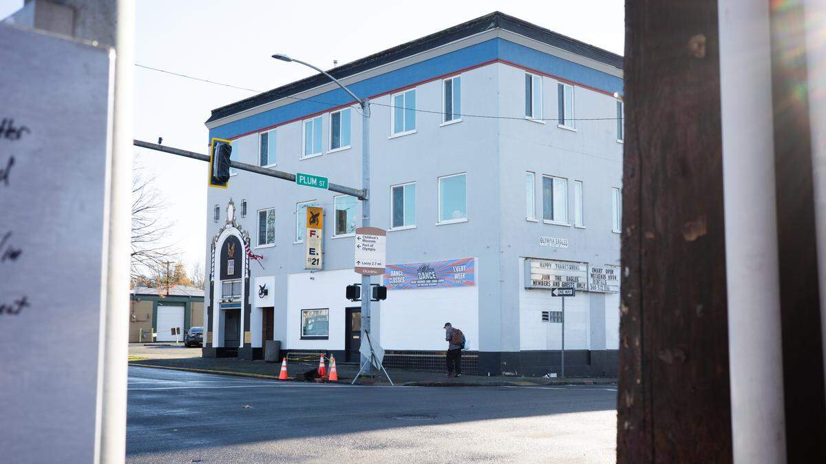 A pedestrian walks past the Eagles Building on the southeast corner of Fourth Avenue and Plum Street in downtown Olympia on Friday, Nov. 28, 2025.