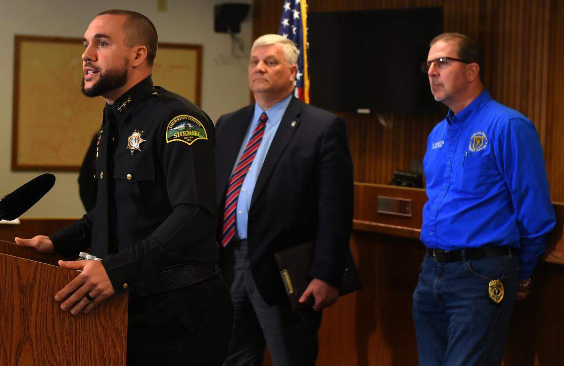 From left, Thurston County Sheriff Derek Sanders, County Prosecuting Attorney Jon Tunheim and County Coroner Gary Warnock hold a news conference to discuss the death of Marcia Norman of Tenino and the charges against Jeffrey Zizz in the case.