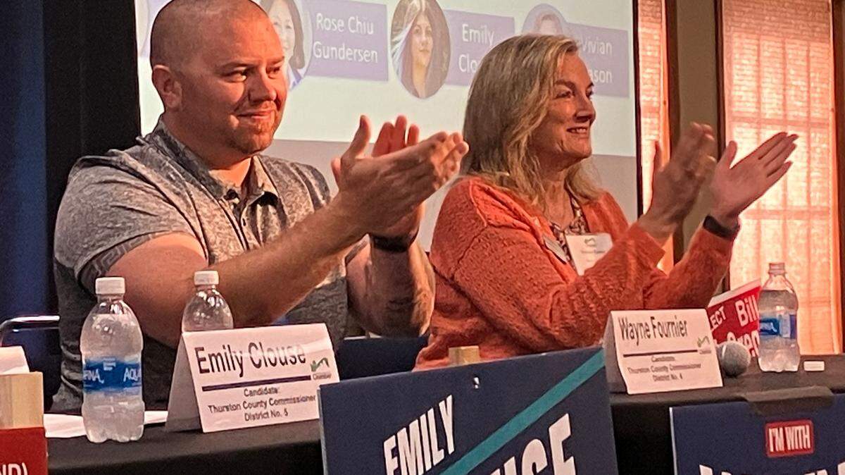 Thurston County District 4 commission candidates Wayne Fournier and Vivian Eason applaud in response to audience members applauding for them at a recent candidate forum.