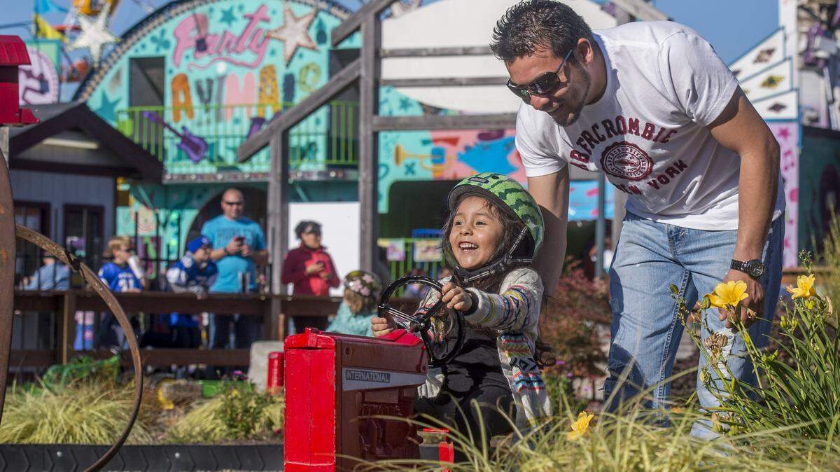 Avril Pena and her dad Fernando have fun in Tractor Tracks at the 2015 Washington State Fair in Puyallup.
