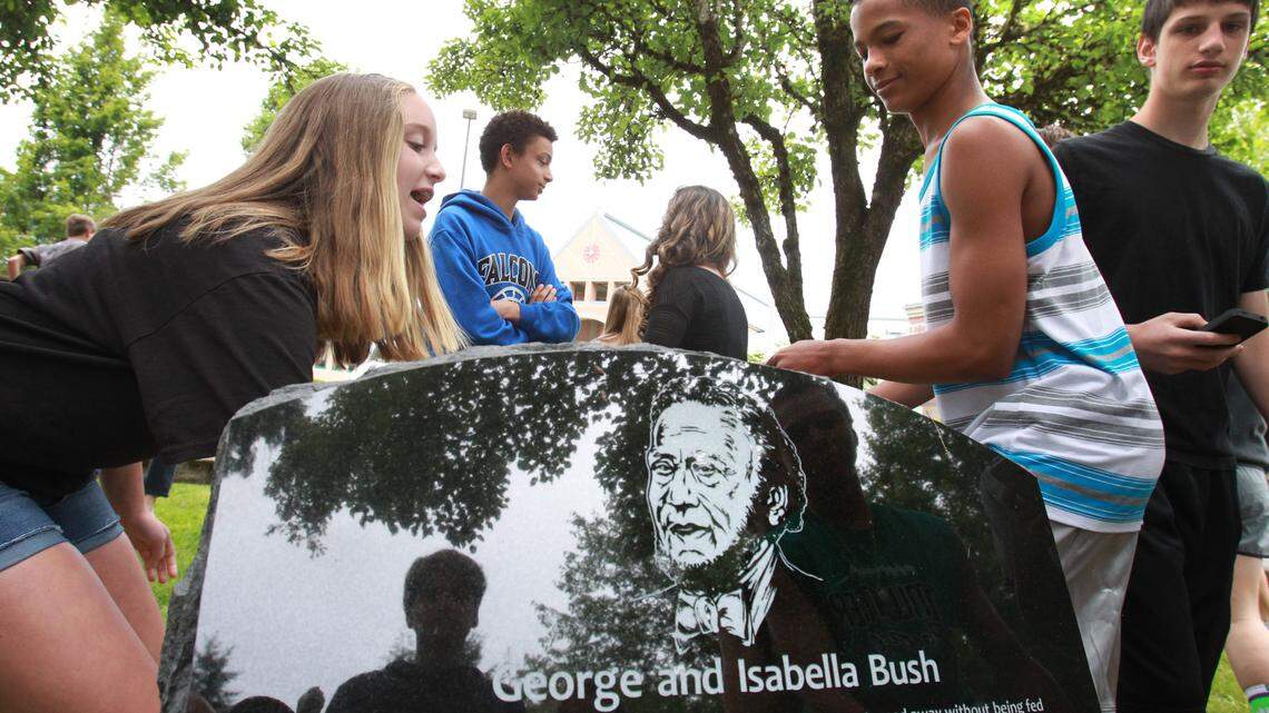 Incoming student body vice president Courtney Borovec (left) and president Brad Blackburn remove the covering to unveil the monument to Tumwater pioneers George and Isabella Bush during ceremonies at Bush Middle School in Tumwater on Thursday, June 12, 2014. The monument also honored Bush’s fellow War of 1812 veterans Jeremiah Mabie and William Rutledge.