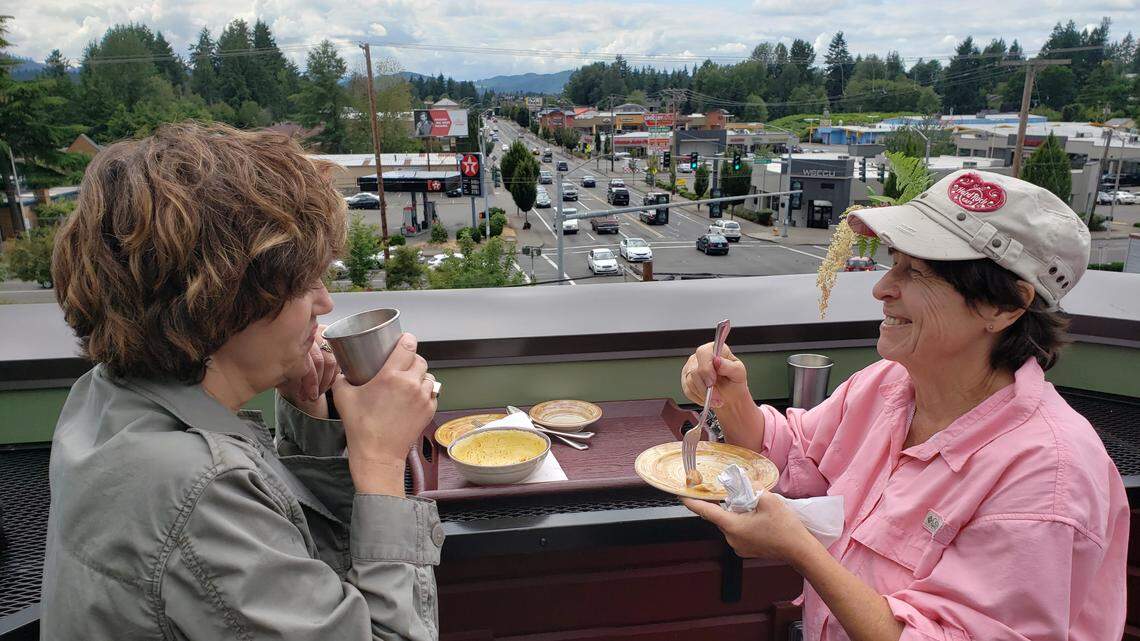 Susan Gresia (left) and Mary Nelson have lunch on the rooftop patio during the July 6 soft opening for the Park Side Cafe.