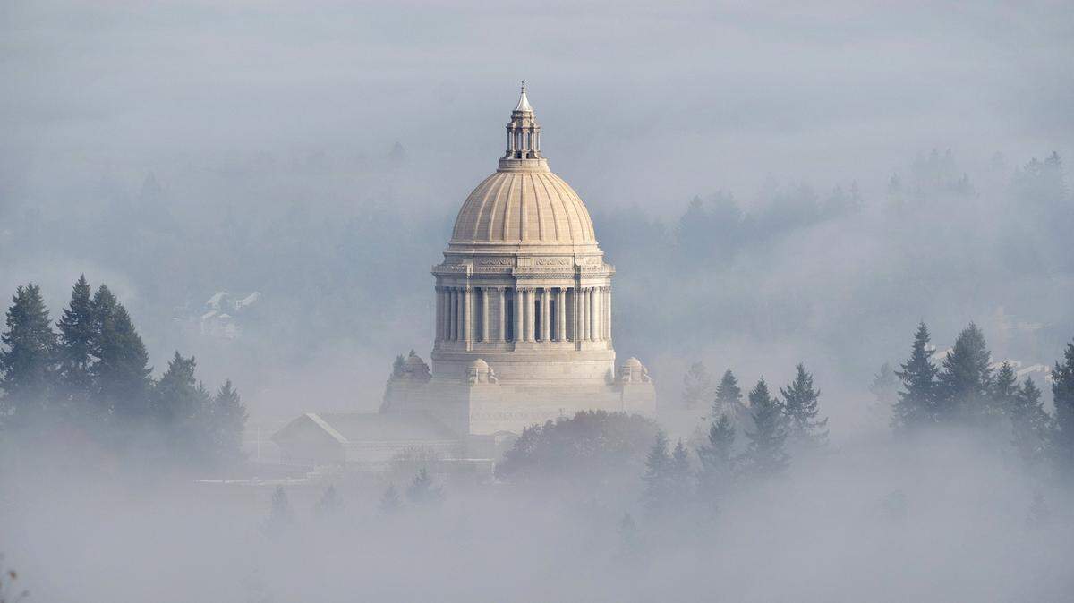 The Washington State Capitol pops out of the morning fog over Olympia earlier this month.