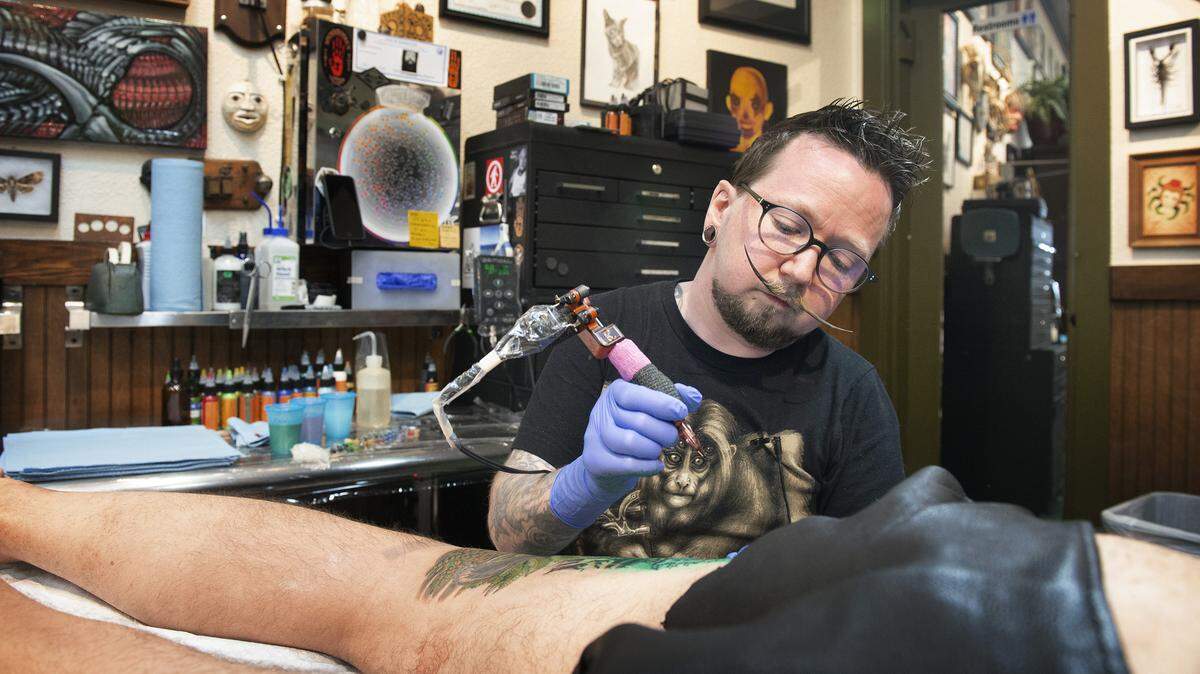 Tattoo artist Bryan Childs works on longtime client Jim Dees of Tennessee at Spidermonkey Tattoos in downtown Olympia on Tuesday. Dees is former Olympia resident who said he makes appointments with Childs whenever he gets back to town.