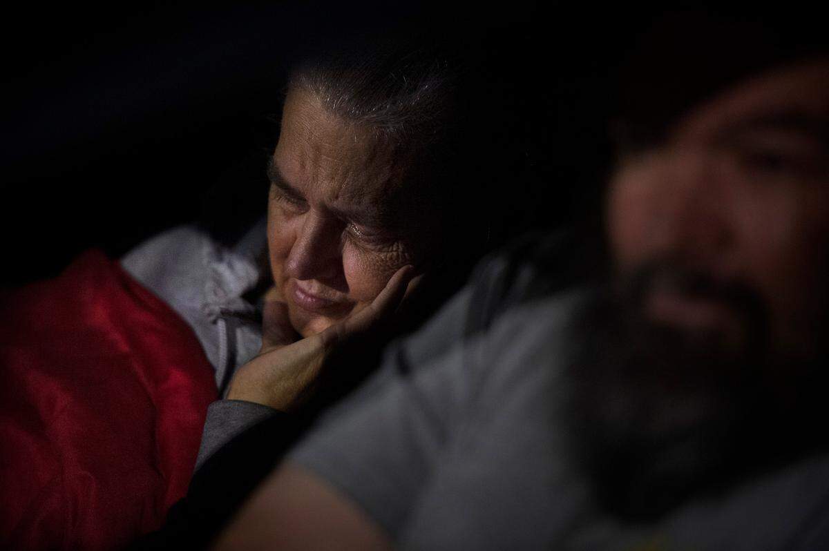 Carol Hampton tries to sleep in the cramped Ford Fiesta alongside husband and caregiver Arnold Hampton, late at night at the Scatter Creek Rest Area along Interstate 5 south of Olympia on July 3. “She goes for dialysis and has to sit for four hours, three times a week,” Arnold said. “And then we come here to sleep in a car where she can’t stretch out. Homeless is hard.”