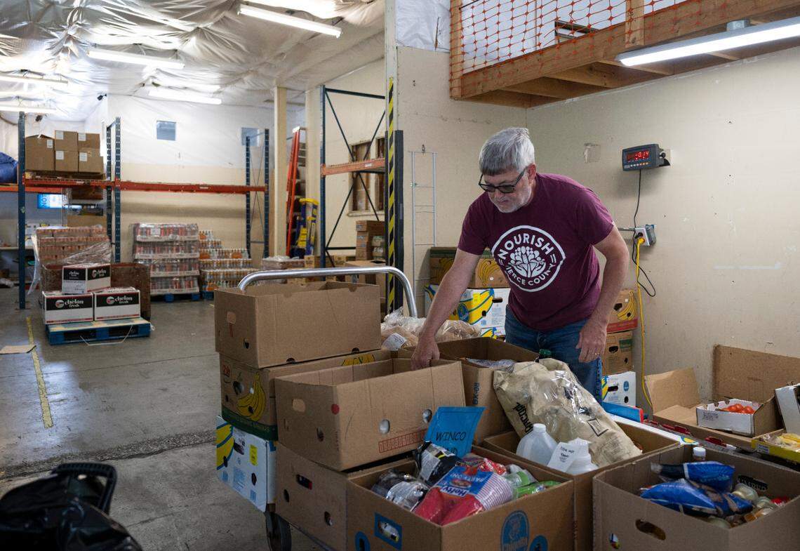 Nourish staff weigh food at the Southeast Tacoma Food Bank at Lutheran Church of Christ the King, on Wednesday, May 7, 2025, in Tacoma, Wash.