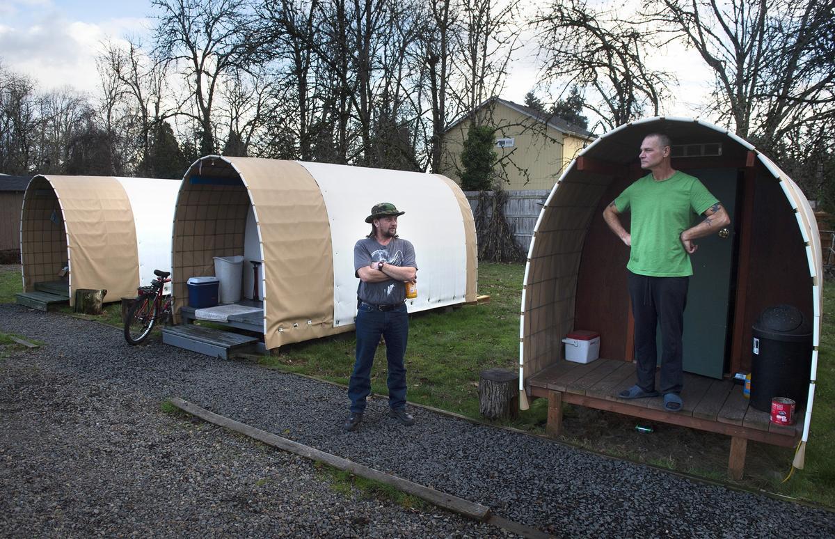 Rick Underwood, left, and Tom McGowan chat outside their Conestoga huts at the Wesley United Methodist Church in Eugene, Oregon. Underwood was preparing to move into an apartment in the coming days. “I lost my job and kinda got left out in the cold. I was afraid to ask for help,” he says. “These people... got me into these places, helping me out with the housing program, got me an apartment. It’s working out.”