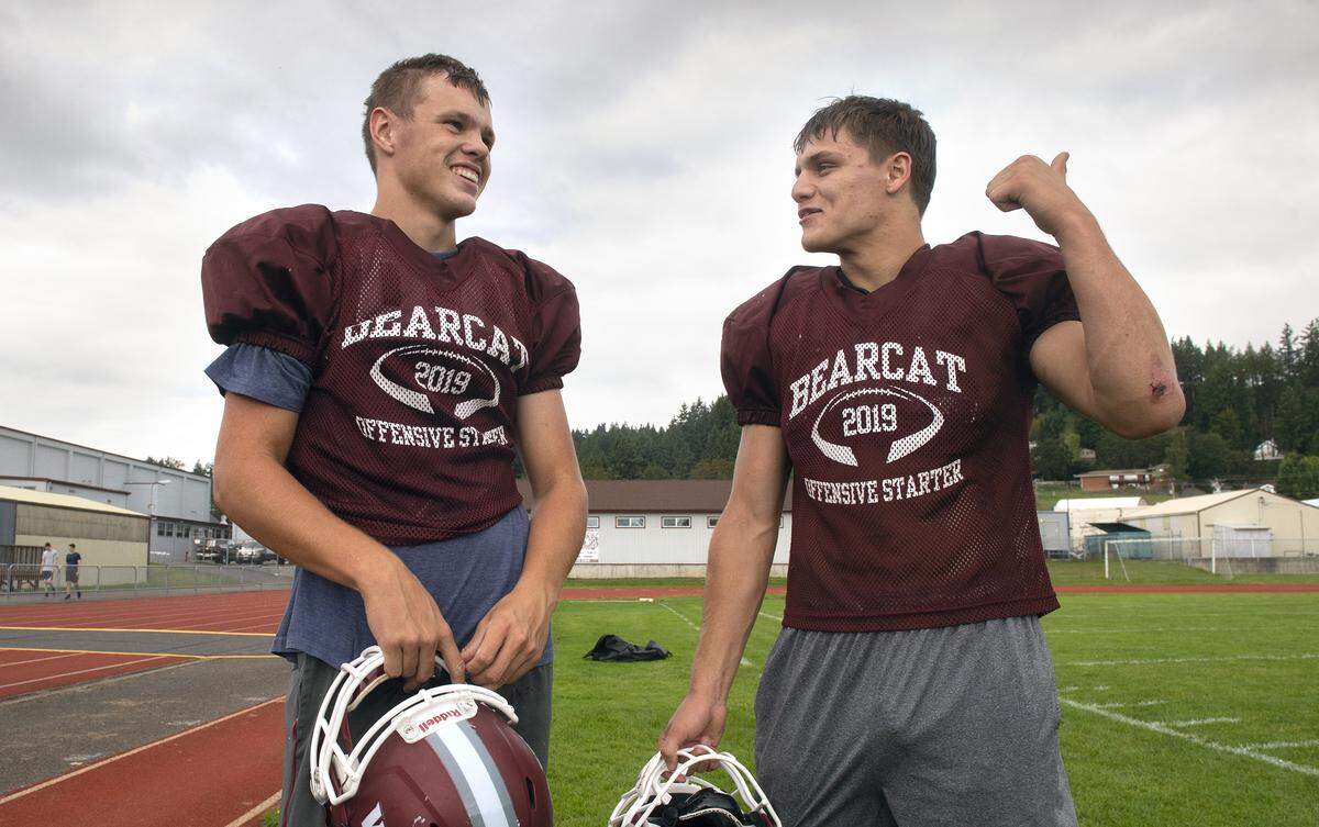 Chehalis quarterback Josiah Johnson (left) and running back Jayden Camoza talk during football practice at W.F. West High School in Chehalis on Thursday, Sept. 26, 2019.