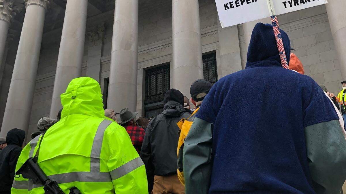 Visitors, gun-rights activists and members from the Oath Keepers, a far-right anti-government organization, open carry weapons at the state capitol on Jan. 31, 2020 during a rally. Legislation passed in 2021 now prohibits open-carrying weapons within 250 feet of state capitol grounds and permitted demonstrations.