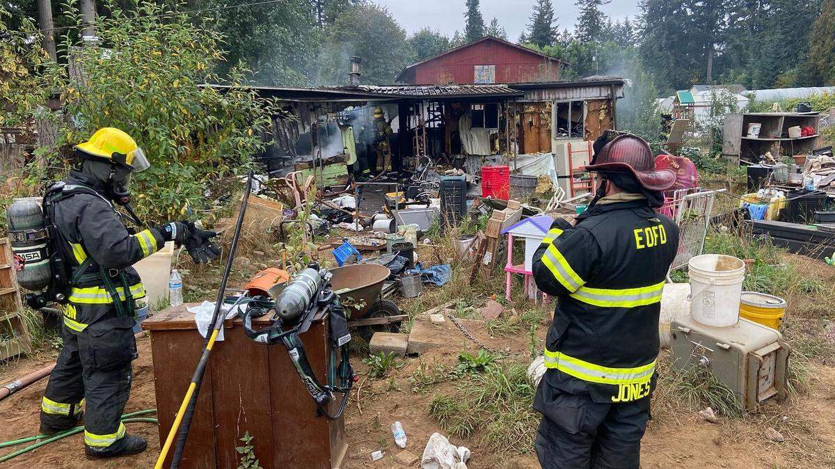 Firefighters from East Olympia Fire District 6 keep watch on a destroyed mobile home on 80th Avenue Southeast in Thurston County on Wednesday, Oct. 5.