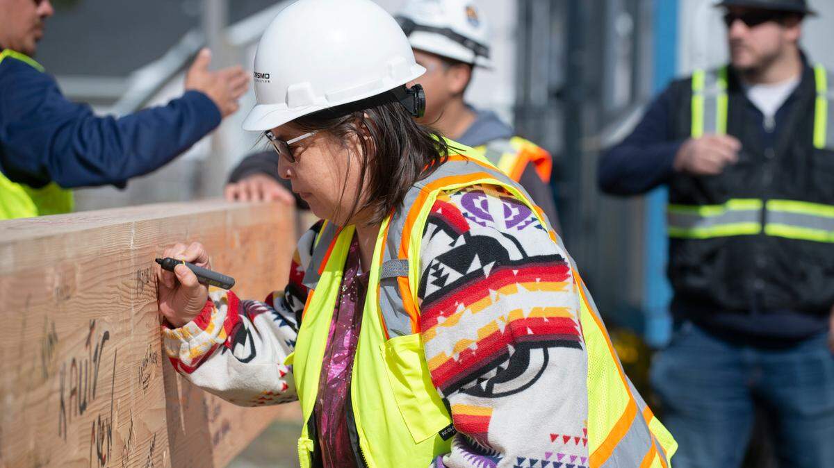 Nisqually Elders Program Manager Cleo Frank signs the final beam of the new elders building before it’s placed on Thursday, May 19. The building is set to open in March 2023.
