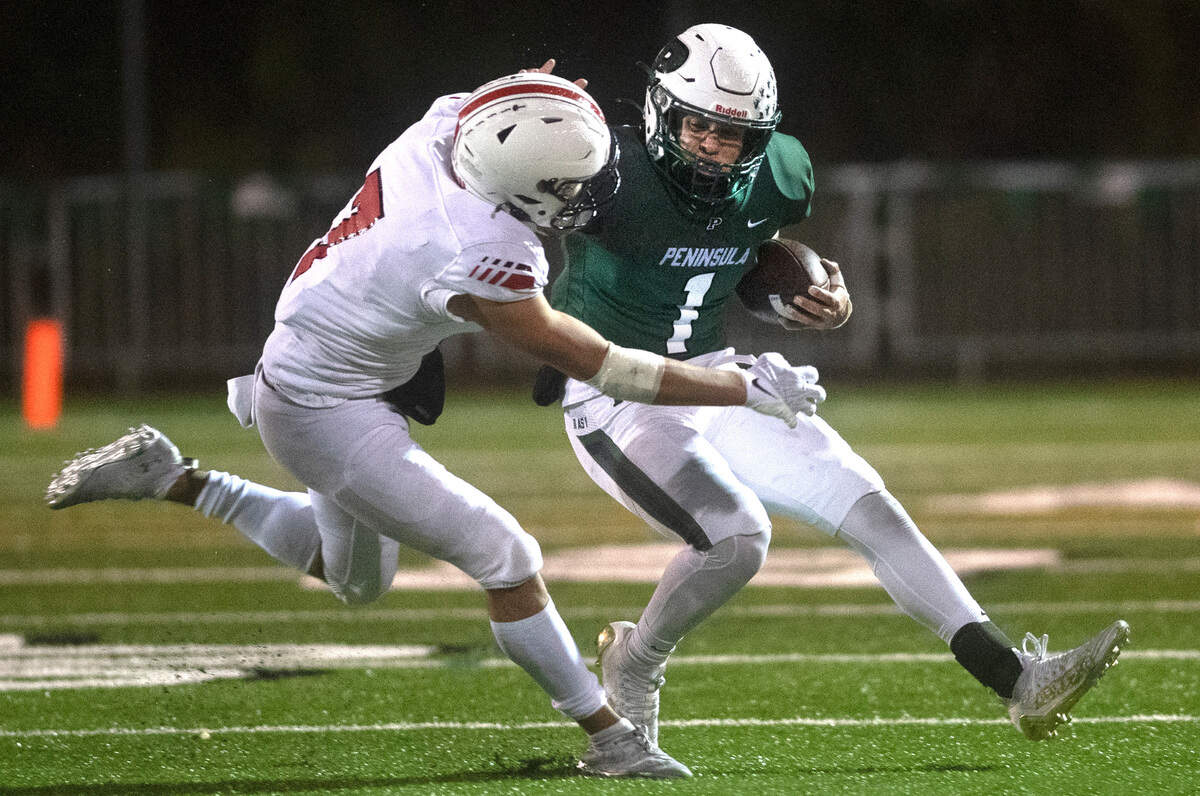 Peninsula running back Isaac Smith is chased down by Yelm defensive back Marius Aalona during Friday night’s football game at Roy Anderson Field in Purdy, Washington, on Oct. 21, 2022.