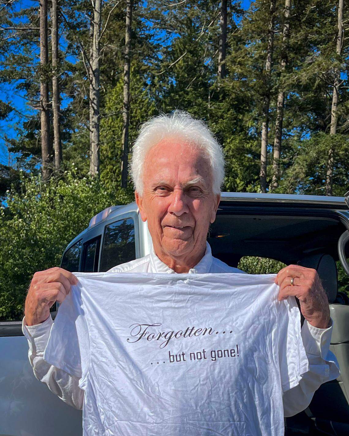 Brian Calder, chairman of the Point Roberts Chamber of Commerce, holds a shirt he made during the early days of the COVID pandemic when border closures isolated the small Washington state community completely bordered by Canada.