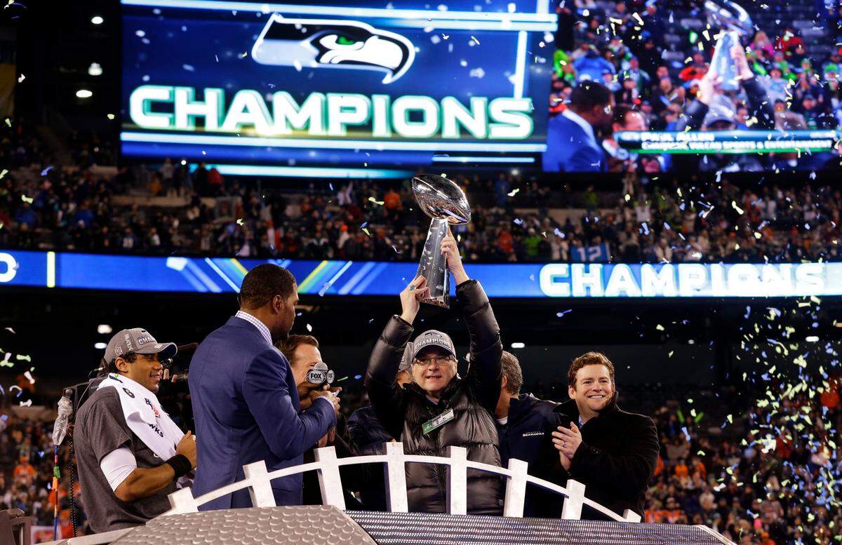 Late Seahawks owner Paul Allen raises the Vince Lombardi Trophy after Seattle won Super Bowl 48 in 2014. General manager John Schneider, far right, confirmed at the NFL combine on Wednesday that Allen’s sister Jody Allen is whom he reports to now. Paul Allen died in October.