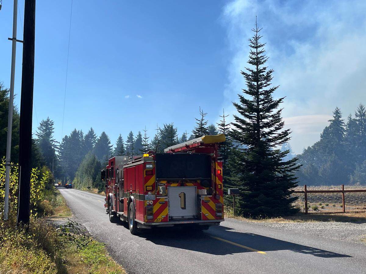 A fire truck is stationed by a wildfire near Rainier in Thurston County on Wednesday, Aug. 13, 2025.