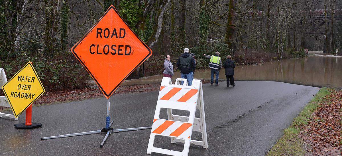 Residents stop by the road block on Sixth Street in Nisqually Thursday morning to watch the rapidly rising Nisqually River.