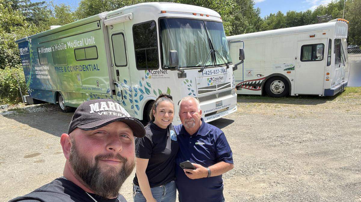 Brandon Simmons in front of bus converted into a medical unit.